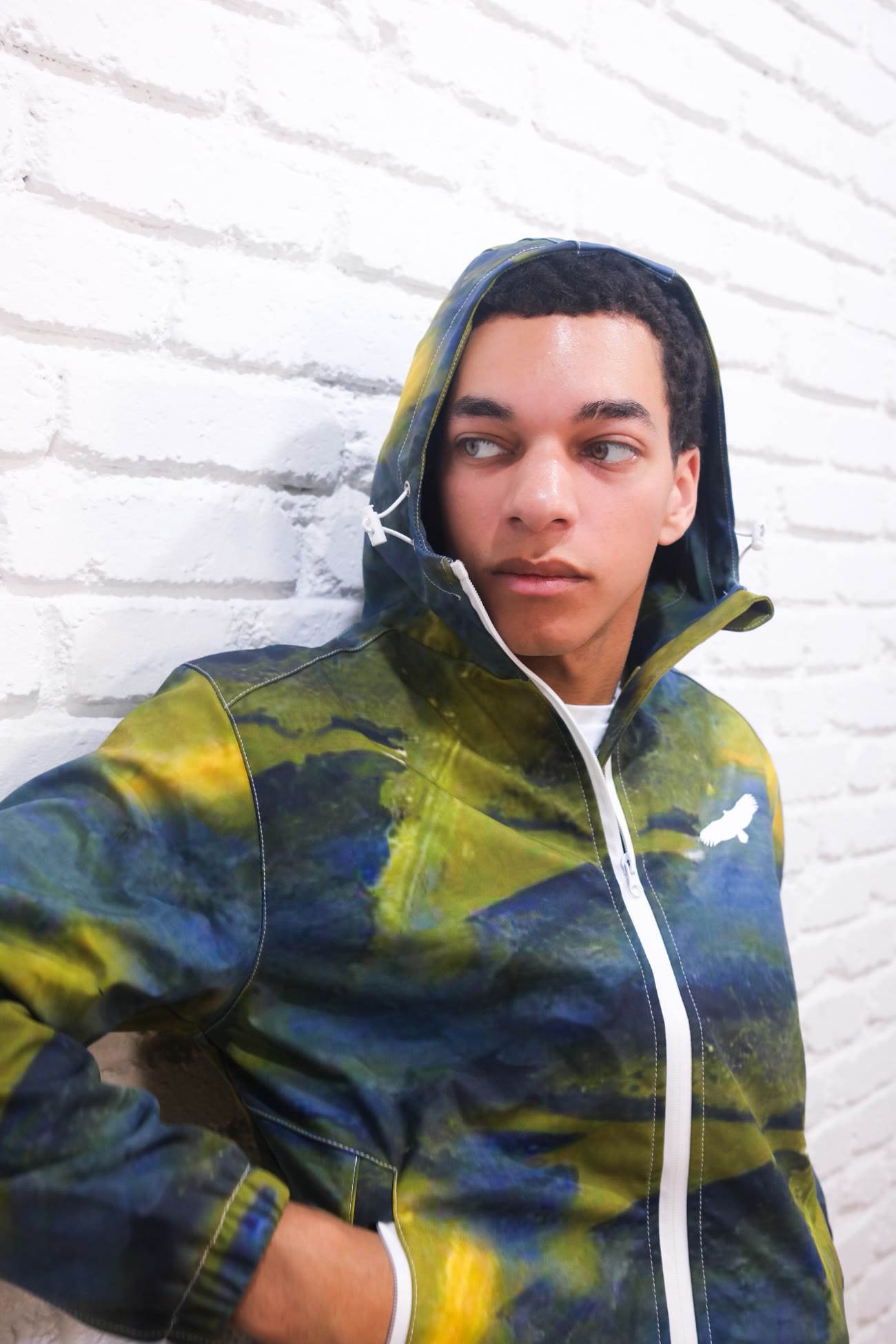 Coupe-vent Green Camo porté capuche relevée, zip blanc et oiseau Vultura sur la poitrine
